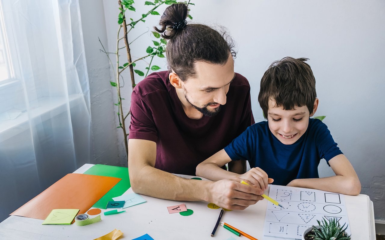 Autistic boy during therapy at home with his father with learnin
